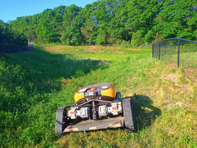 Remote-controlled slope mower maintaining retention pond in Simpsonville South Carolina