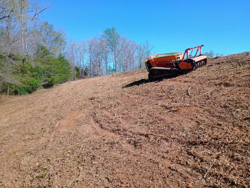 Dam in Campobello South Carolina after brush clearing with remote-controlled slope mower on steep terrain