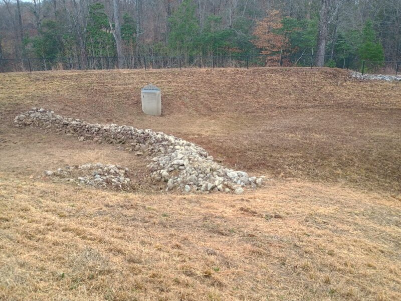 Retention pond drain and rip rap area neatly mowed and cleared for visibility and maintenance access